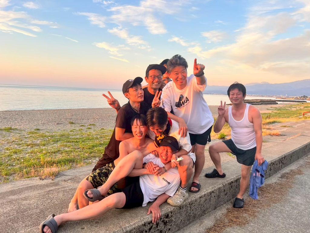 浜黒崎キャンプ場で夕日の海辺に集まるみんな