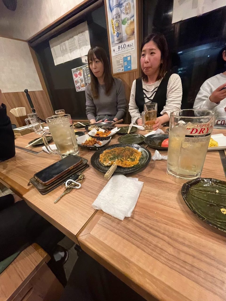 居酒屋のテーブルを囲むみんな